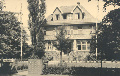 מנפרד ניצב בפתח בית הוריו בבורקן, 1945